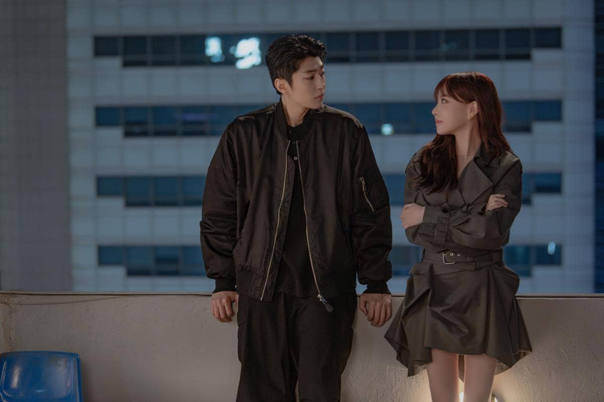 Dua karakter dalam drama Dream to You berdiri di atap gedung pada malam hari, saling menatap dengan ekspresi serius dan lembut.