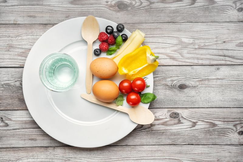Ilustrasi Puasa Interval fasting diet. Intermittent fasting concept represented with a plate and products on gray background. Healthy lifestyle. Fat loss concept. Top view