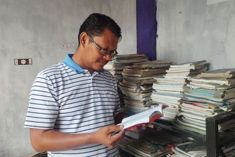 Pendiri Yayasan Sekolah Alam Istana Hati, Suwardiyamsyah, S.Ag sedang membaca sembari merapikan buku-buku yang ada di rak perpusatakaan sekolah di Jalan Arif Rahman Hakim No. 66, Lingkungan III, Kelurahan Nangka, Kecamatan Binjai Utara, Kota Binjai, Provinsi Sumatera Utara, Sabtu (18/7/2026).